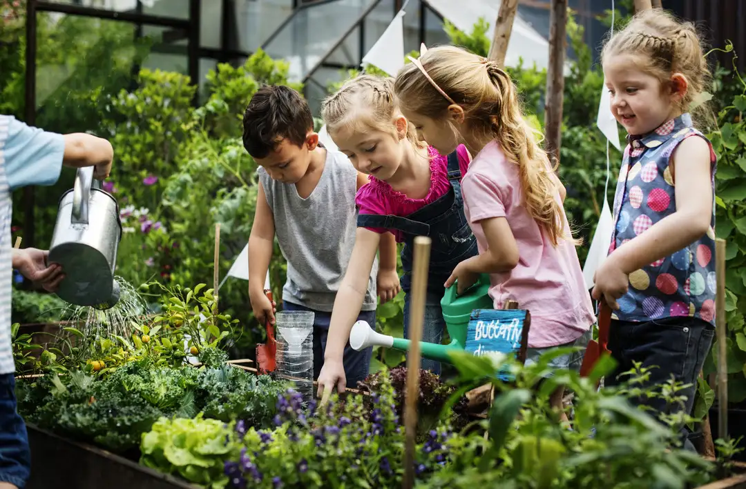 Grupo de niños de guardería que aprenden jardinería al aire libre